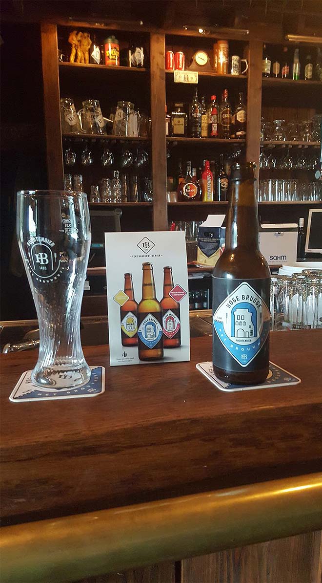 photo of hoge brugge beer bottle, poortenbier glass and table tent inside a Harderwijk bar